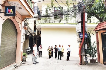 Cán bộ, người dân phường Nghĩa Đô, quận Cầu Giấy giám sát việc lắp đặt camera an ninh trên địa bàn phường. 