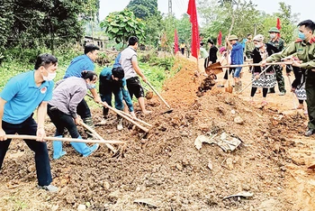 Cán bộ các cơ quan tỉnh Tuyên Quang giúp dân làm đường giao thông.
