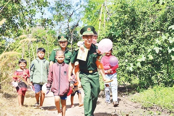 Bộ đội Biên phòng Bình Phước giúp các em học sinh đến trường.