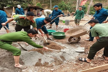 Lực lượng công an huyện và dân quân tự vệ ở Tương Dương hỗ trợ những hộ nghèo, neo đơn làm nhà ở.
