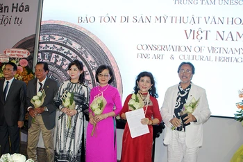 Ông Phạm Hoàng Thịnh (bìa trái), Trưởng Văn phòng đại diện Liên Hiệp các Hội UNESCO Việt Nam tại Thành phố Hồ Chí Minh trao quyết định và chúc mừng Ban Giám đốc Trung tâm.