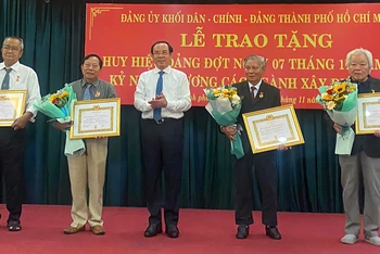 Đồng chí Nguyễn Văn Nên, Ủy viên Bộ Chính trị, Bí thư Thành ủy Thành phố Hồ Chí Minh trao Huy hiệu 55 năm tuổi Đảng và Huy hiệu 50 năm tuổi Đảng cho các đảng viên.