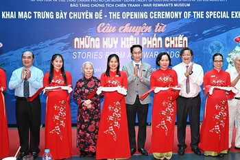 Nghi thức cắt băng khai mạc trưng bày chuyên đề "Câu chuyện từ những huy hiệu phản chiến". (Ảnh: Quốc Thanh)