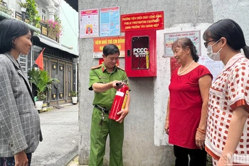 Công an phường Tân Chánh Hiệp (quận 12) hướng dẫn người dân sử dụng bình chữa cháy.