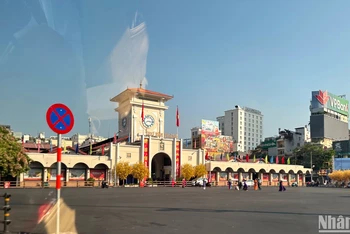 Người dân chụp hình, tham quan trước cổng chợ Bến Thành (quận 1) sau kỳ nghỉ Tết. Ảnh: MINH CHÁNH