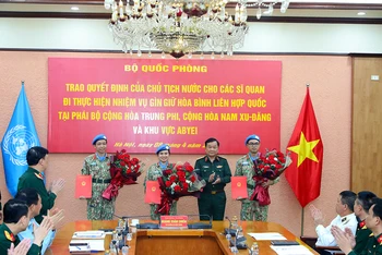 Thượng tướng Hoàng Xuân Chiến trao Quyết định của Chủ tịch nước và tặng hoa chúc mừng ba sĩ quan đi thực hiện nhiệm vụ gìn giữ hòa bình Liên hợp quốc.