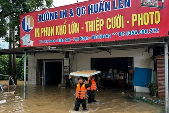 Cán bộ, chiến sĩ Trung đoàn 18, Sư đoàn 325 giúp nhân dân thôn Hạ Long, xã Giáp Sơn, huyện Lục Ngạn, tỉnh Bắc Giang, chuyển đồ đạc đến nơi an toàn. 