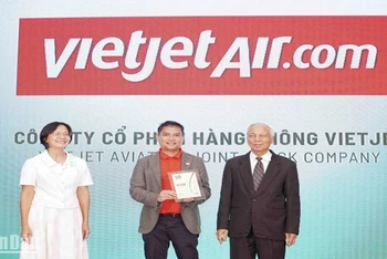 Ông Nguyễn An Di, Giám đốc Nhân sự Vietjet (đứng giữa) nhận giải thưởng tôn vinh 50 doanh nghiệp phát triển bền vững từ ban tổ chức.