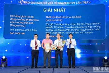 Đồng chí Lê Quốc Minh, Ủy viên Trung ương Đảng, Tổng Biên tập Báo Nhân Dân, Phó Trưởng ban Tuyên giáo Trung ương, Chủ tịch Hội Nhà báo Việt Nam và đồng chí Nguyễn Văn Thắng, Ủy viên Trung ương Đảng, Bộ trưởng Giao thông vận tải trao giải Nhất cho các tác giả. (Ảnh: Tạ Hải)