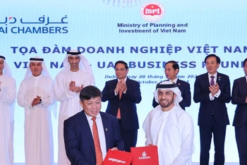 Đại diện lãnh đạo Vietjet (trái) và Emirates (phải) trao thỏa thuận hợp tác mở rộng kết nối quốc tế trước sự chứng kiến của Thủ tướng Phạm Minh Chính (giữa) tại Dubai, UAE.