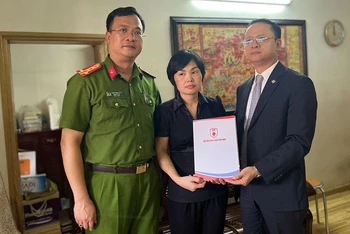Đại diện Phòng Cảnh sát PCCC&CNCH và Hiệp hội PCCC và CNCH Việt Nam trao tặng sổ tiết kiệm cho gia đình Liệt sĩ Nguyễn Đình Phúc.
