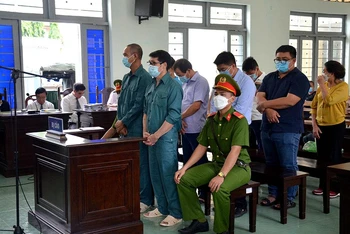 Bị cáo Luyện Xuân Tràng (đứng hàng trước, đeo kính) cùng 8 bị cáo tại phiên tòa.
