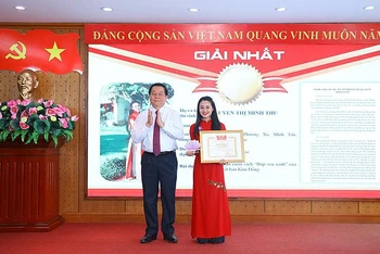 Đồng chí Nguyễn Trọng Nghĩa trao giải nhất Cuộc thi tặng thí sinh Nguyễn Thị Minh Thu. 