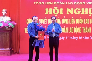 Chủ tịch Tổng Liên đoàn Lao động Việt Nam Nguyễn Đình Khang trao Quyết định và tặng hoa chúc mừng tân Chủ tịch Liên đoàn Lao động thành phố Hải Phòng Nguyễn Anh Tuân. 