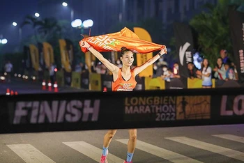 Một nữ vận động viên về đích tại giải chạy Longbien Marathon 2022 sáng sớm 30/10.