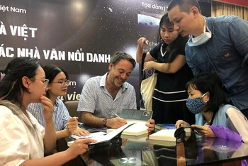 Nhà văn Michel Bussi ký tặng sách cho bạn đọc Việt Nam trong sự kiện tọa đàm, giao lưu do Nhã Nam tổ chức.