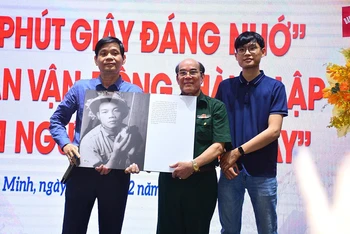 Cựu chiến binh Nguyễn Minh Vỹ tặng bức ảnh Liệt sĩ Phạm Văn Cao do ông chụp tại chiến trường Quảng Trị đến thân nhân liệt sĩ.