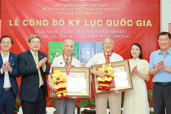 Thầy thuốc Ưu tú Nguyễn Đức Đoàn (thứ ba từ trái sang) và bác sĩ Nguyễn Hữu Trọng (thứ tư từ trái sang) nhận chứng nhận từ đại diện Tổ chức kỷ lục Việt Nam.