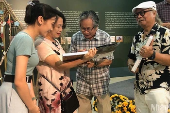 Tác giả, họa sĩ Trịnh Lữ ký sách cho độc giả tại buổi ra mắt sách.