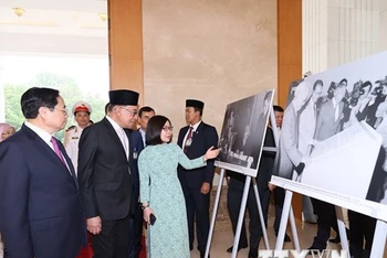 Thủ tướng Phạm Minh Chính và Thủ tướng Malaysia Anwar Ibrahim tham quan trưng bày ảnh của Thông tấn xã Việt Nam. (Ảnh: TTXVN)