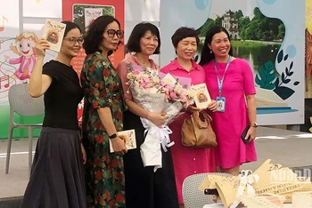 Tác giả Vũ Thị Minh Họa (ôm hoa, đứng giữa) tại buổi ra mắt sách.