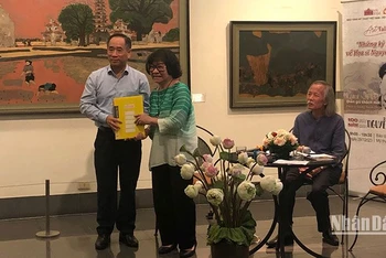 Họa sĩ Đặng Thị Khuê trao cho Giám đốc Bảo tàng Mỹ thuật Việt Nam Nguyễn Anh Minh những tư liệu về họa sĩ Nguyễn Sáng.