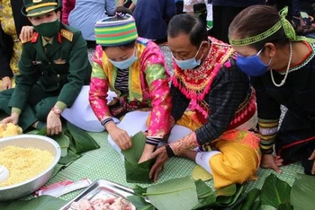 Đồng bào dân tộc cùng các chiến sĩ tham gia Chương trình gói "Bánh chưng xanh" tại Làng. (Ảnh: Làng Văn hóa-Du lịch các dân tộc Việt Nam)