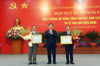Trưởng Ban Tuyên giáo Trung ương Nguyễn Trọng Nghĩa (giữa) trao huy hiệu 40 năm tuổi Đảng tặng các đồng chí đảng viên.