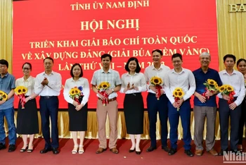 Các đồng chí trong Ban Thường vụ Tỉnh ủy Nam Định tặng hoa chúc mừng các tập thể có thành tích tiêu biểu trong triển khai hưởng ứng Giải Búa liềm vàng lần thứ VII năm 2022.