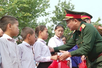 Thượng tướng Hoàng Xuân Chiến, Thứ trưởng Quốc phòng tặng quà các cháu học sinh tại cụm bản Pha Thi. (Ảnh: TRỊNH DŨNG)