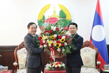 Đại sứ Nguyễn Bá Hùng tặng hoa chúc mừng Phó Thủ tướng, Bộ trưởng Ngoại giao Lào Saleumxay Kommasith nhân dịp Tết cổ truyền Bun Pi May 2023 của Lào. (Ảnh: Trịnh Dũng)