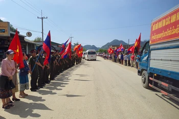Đông đảo người dân tỉnh Xiengkhouang tập trung dọc hai bên đường vẫy cờ, hoa, viếng tiễn biệt các anh hùng liệt sĩ. (Ảnh: Trịnh Dũng)