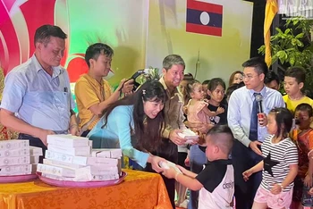 Ban tổ chức trao quà cho các cháu thiếu nhi là con em cộng đồng người Việt Nam tại Lào. (Ảnh: HẢI TIẾN)