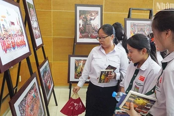 Các em học sinh Lào tham quan triển lãm. (Ảnh: HẢI TIẾN)