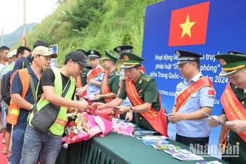 Cán bộ, chiến sĩ Đồn Biên phòng Tân Thanh, huyện Văn Lãng, Lạng Sơn (Việt Nam) và lực lượng chức năng Trạm Kiểm tra Biên phòng Pò Chài, Quảng Tây (Trung Quốc), phối hợp phát tờ rơi tuyên truyền pháp luật cho người dân qua lại biên giới. 