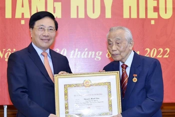 Phó Thủ tướng Thường trực Chính phủ Phạm Bình Minh trao tặng huy hiệu 75 năm tuổi Đảng tặng đồng chí Nguyễn Mạnh Cầm. (Ảnh: baoquocte.vn)