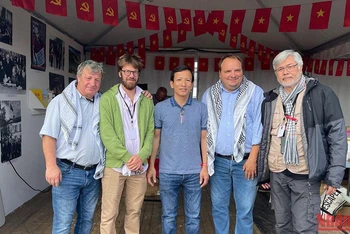 Đồng chí Fabien Gay, Tổng Biên tập báo L'Humanité (thứ 2 từ phải sang) và đồng chí Vadim Kamenka (thứ 2 từ trái sang), phụ trách Làng Quốc tế, tới thăm Gian trưng bày Việt Nam. 