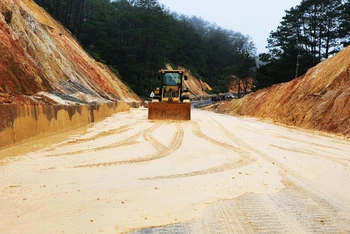 Xe ủi được huy động để san phần bùn, đất sạt lở xuống Quốc lộ 24, đoạn qua xã Đăk Ring, huyện Kon Plông