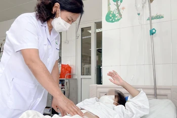TS, BS Nguyễn Việt Hoa - Trưởng khoa Phẫu thuật Nhi và Trẻ sơ sinh thăm khám cho bệnh nhân.