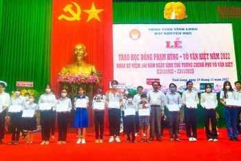 Phó Bí thư thường trực Tỉnh ủy Vĩnh Long Nguyễn Thành Thế trao học bổng cho các em học sinh vượt khó học giỏi. (Ảnh: BÁ DŨNG) 