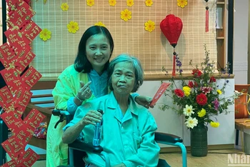 Bà Tạ Thị Dư (76 tuổi, thị trấn Phùng, Hà Nội) cùng con gái tại hội chợ xuân. 