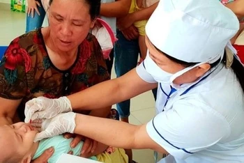 Cán bộ y tế tại xã Phù Ngọ, Cao Bằng cho trẻ uống vitamin A. (Ảnh: T.Linh)