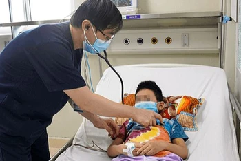 Tiến sĩ, bác sĩ Đào Hữu Nam, Trưởng khoa Điều trị tích cực, Trung tâm bệnh nhiệt đới thăm khám cho bệnh nhi trước khi ra viện.