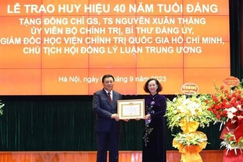 Thường trực Ban Bí thư Trương Thị Mai trao Huy hiệu 40 năm tuổi Đảng cho đồng chí Nguyễn Xuân Thắng. (Ảnh: Văn Điệp/TTXVN)