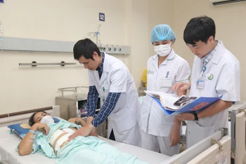 Bác sĩ Nguyễn Đạo Uyên, Khoa Phẫu thuật Tiết niệu thăm khám cho bệnh nhân sau phẫu thuật.