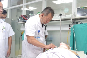 Tiến sĩ Dương Đức Hùng, Giám đốc Bệnh viện Hữu nghị Việt Đức khám cho bệnh nhân trước khi đưa vào phòng mổ. (Ảnh: BVCC)