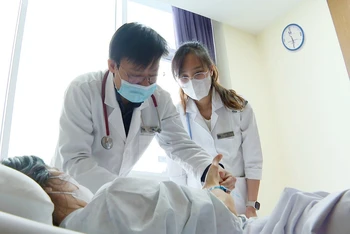 Bác sĩ khám cho bệnh nhân nữ mắc bệnh thủy đậu đang nằm viện. 