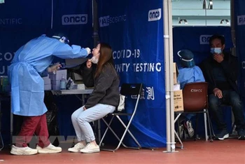 Nhân viên y tế lấy mẫu xét nghiệm Covid-19 cho người dân tại Hồng Kông (Trung Quốc). (Ảnh: AFP/TTXVN)