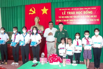 Đại diện Bộ đội Biên phòng tỉnh và Hội khuyến học tỉnh Sóc Trăng trao học bổng cho các em học sinh. (Ảnh: VĂN LONG)