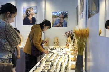 Khách nước ngoài tham quan, tìm hiểu những sản phẩm thủ công mỹ nghệ giới thiệu tại Hội chợ Hanoi Gift Show 2022.